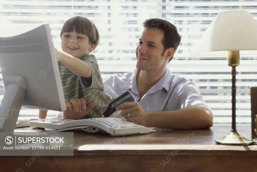 Father and son sitting in front of a computer