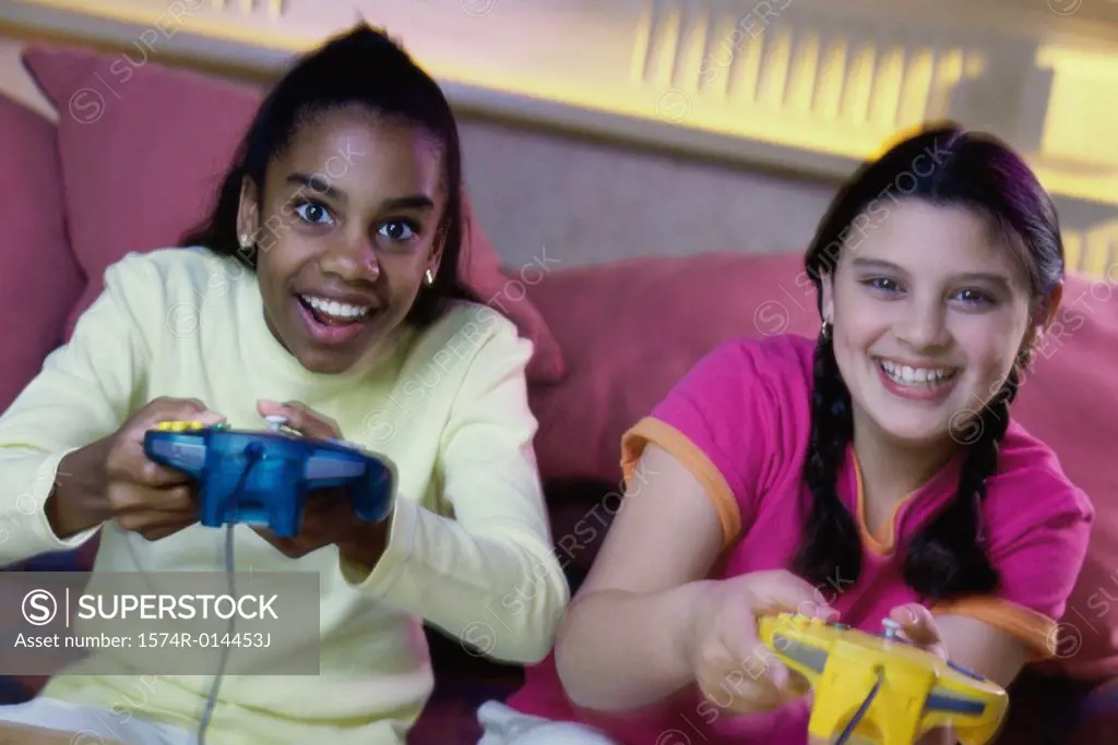 Portrait of two teenage girls playing video games