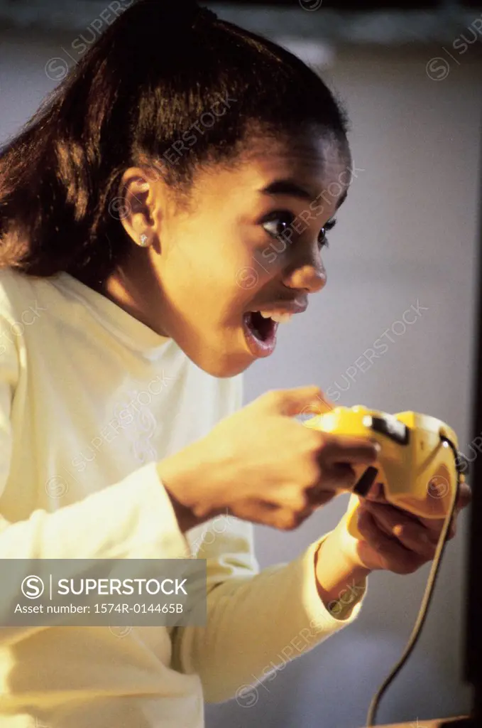 Side profile of a teenage girl playing video games