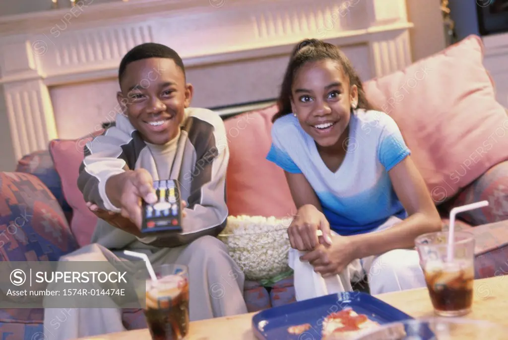 Close-up of a brother and sister watching television