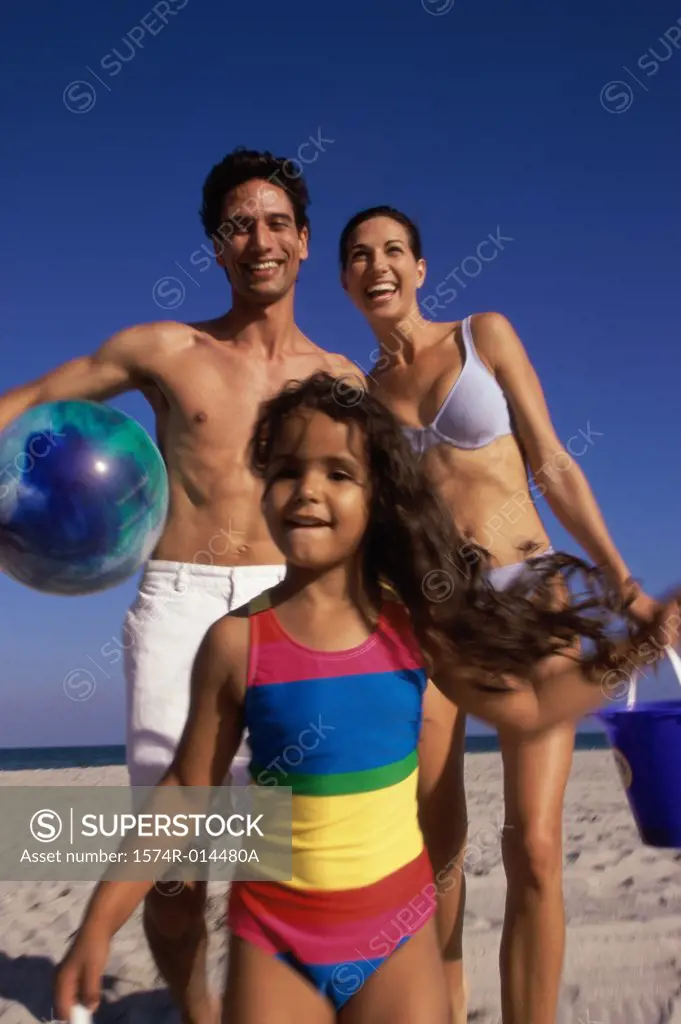 Low angle view of parents and their daughter standing on the beach