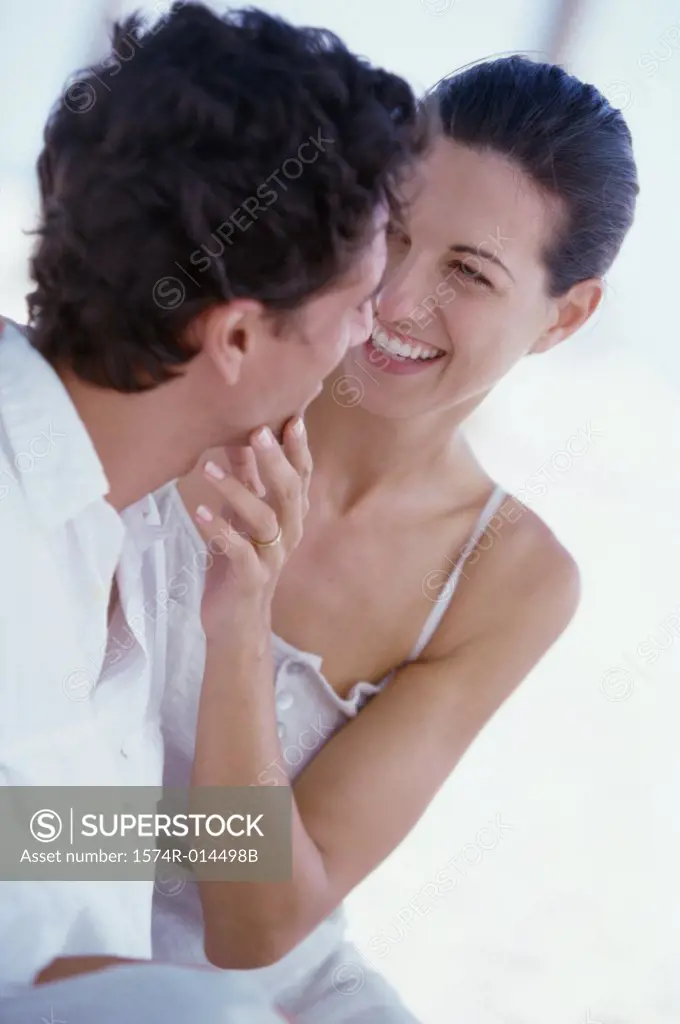 Close-up of a young woman touching the face of a young man