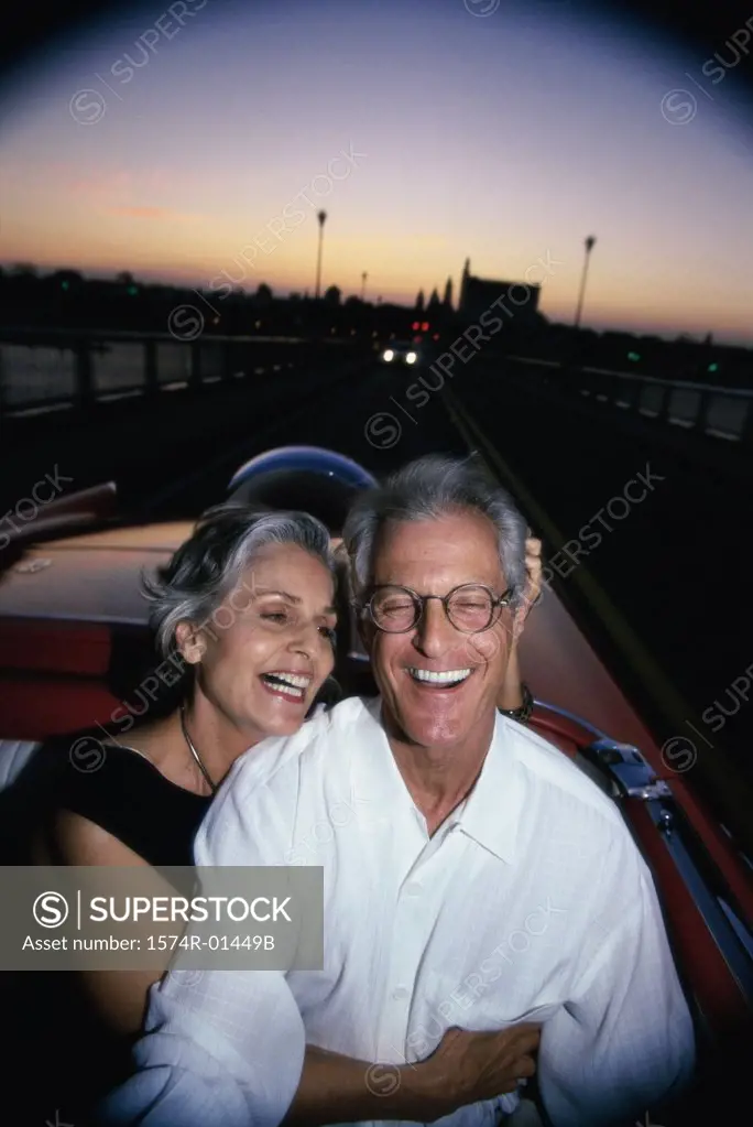 Senior couple sitting in a convertible car