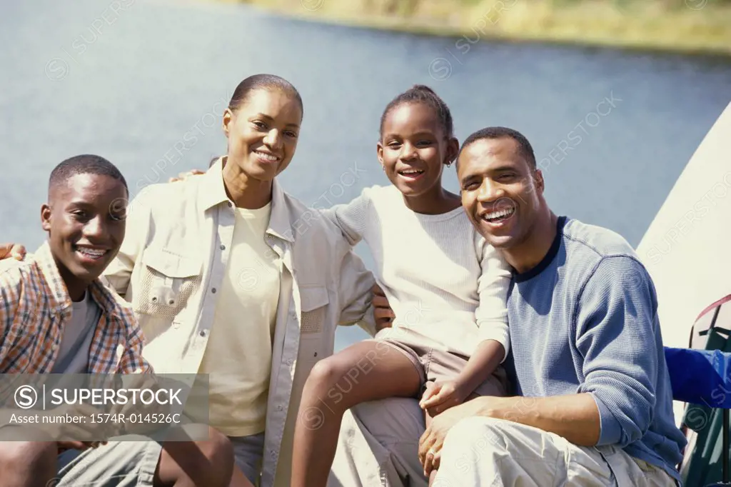 Portrait of parents sitting at a campsite with their son and daughter