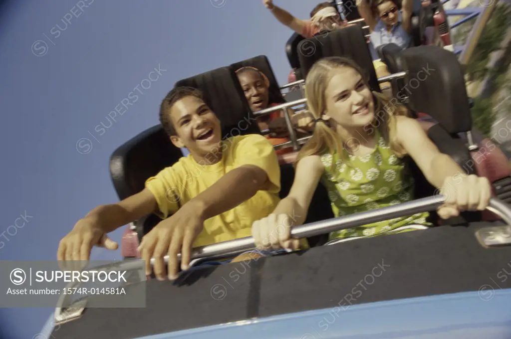 Teenage couple riding a rollercoaster