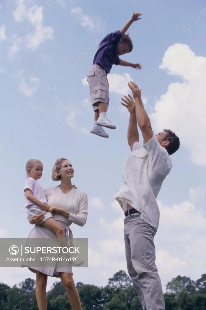 Side profile of a father tossing his son in the air