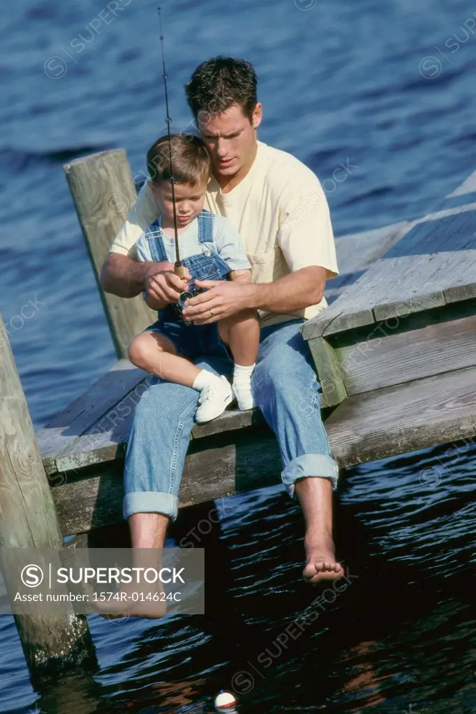 High angle view of a father teaching his son to fish