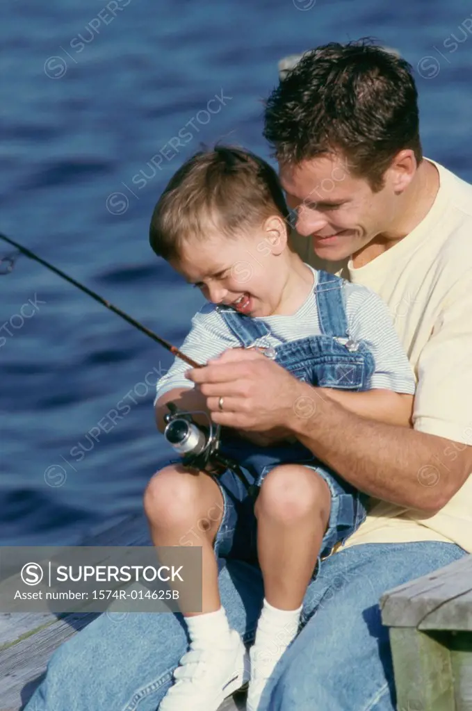 Close-up of a father teaching his son to fish