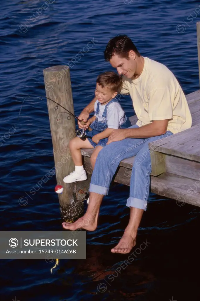 High angle view of a father teaching his son to fish