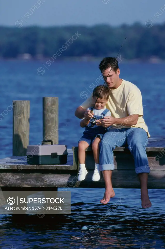 Father and son sitting on a pier fishing