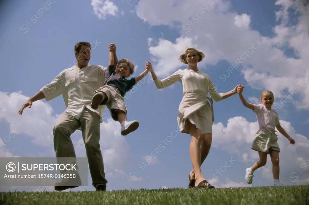 Low angle view of parents swinging their son