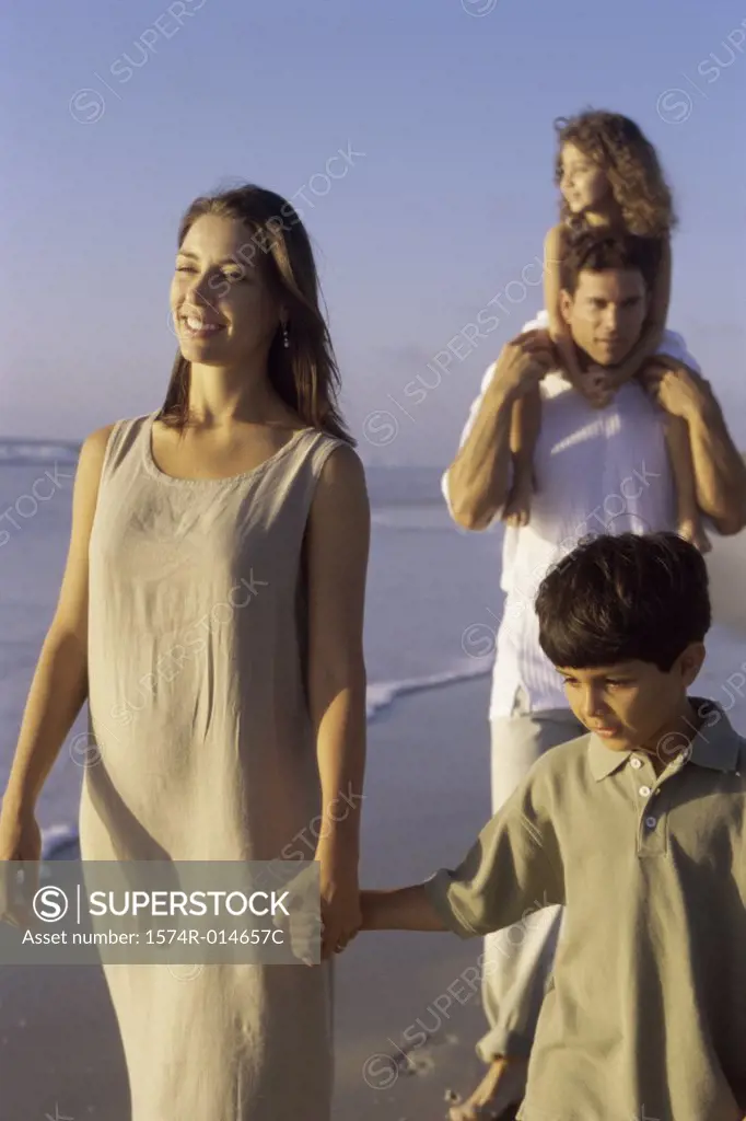 Parents and their two children walking on the beach