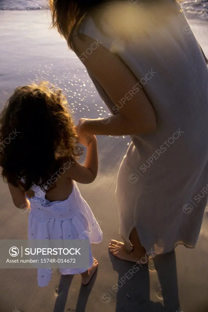 Rear view of a mother with her daughter on the beach