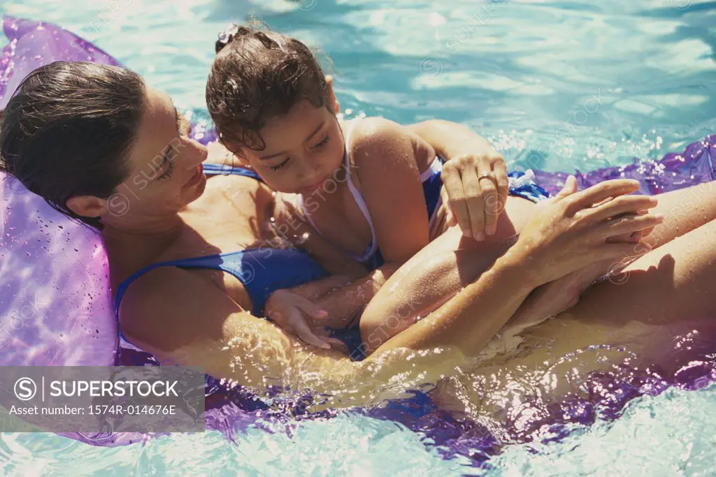 High angle view of a mother with her daughter on a pool raft in a swimming pool
