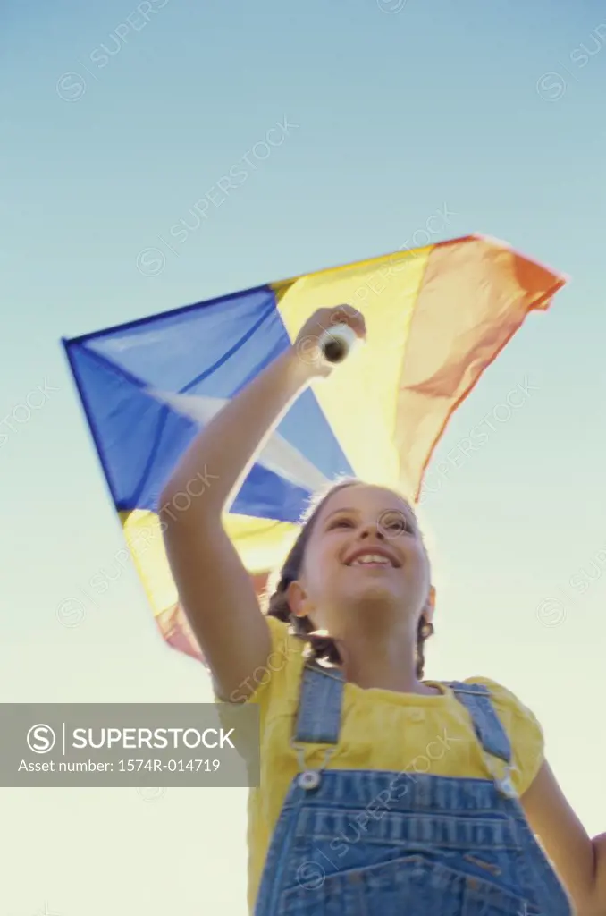 Low angle view of a girl flying a kite