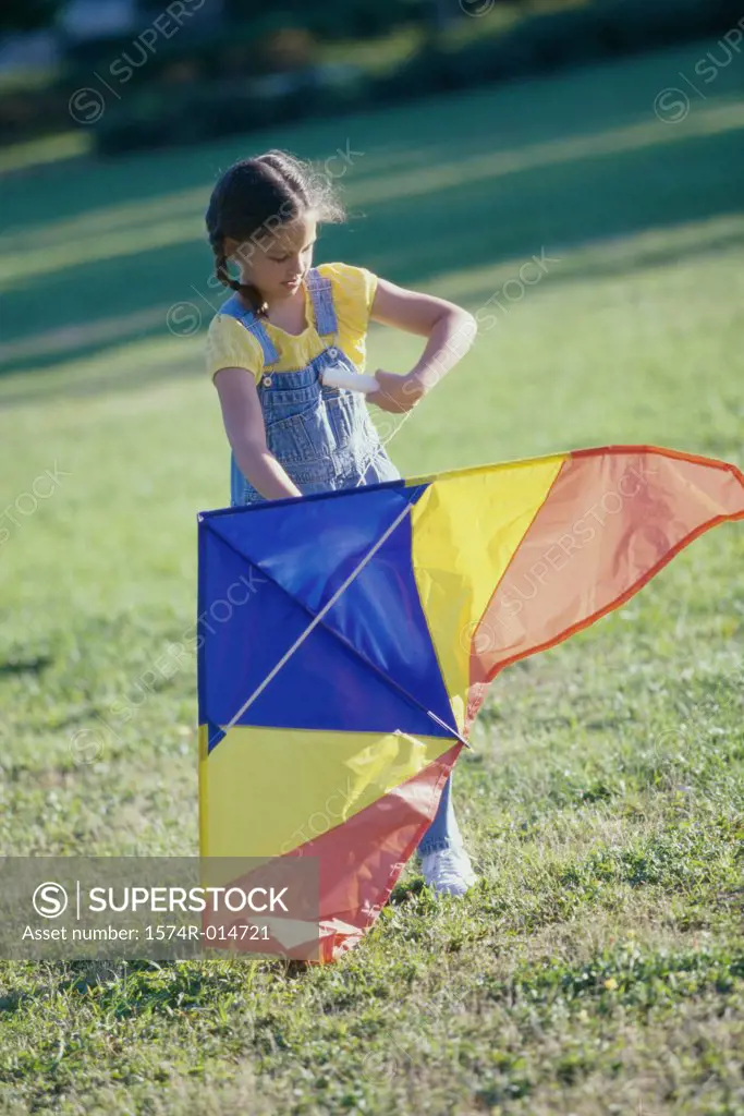 Girl holding a kite on a lawn