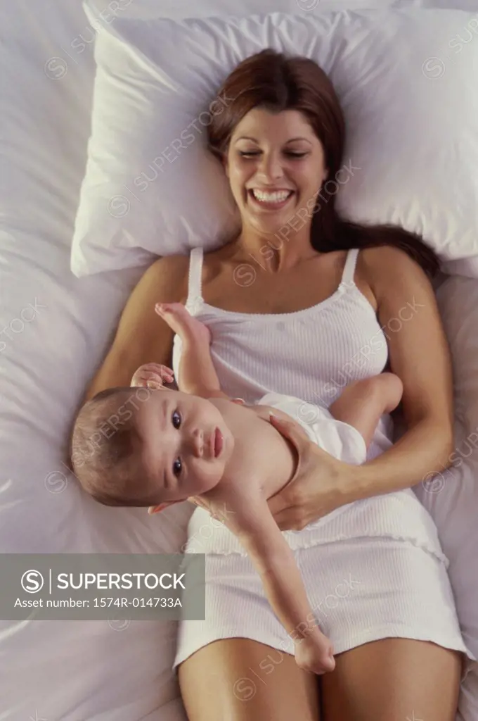 High angle view of a mother lying in bed playing with her son