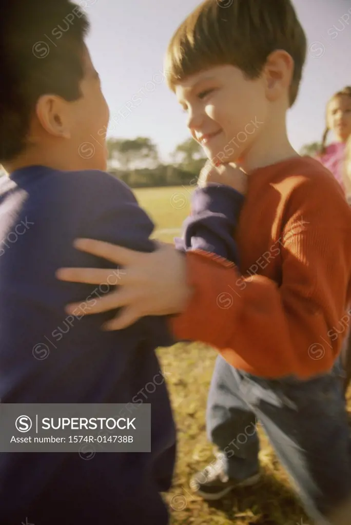 Side profile of two boys playing in a lawn