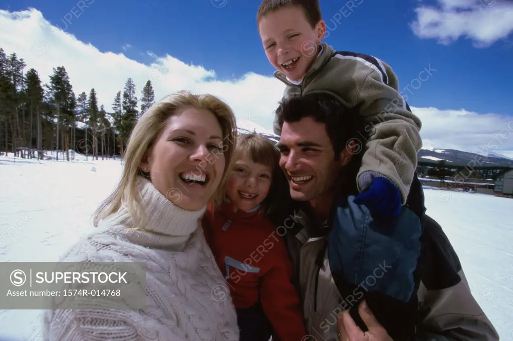 Close-up of parents smiling with their son and daughter