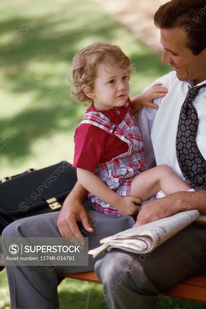 High angle view of a boy sitting on his father's lap