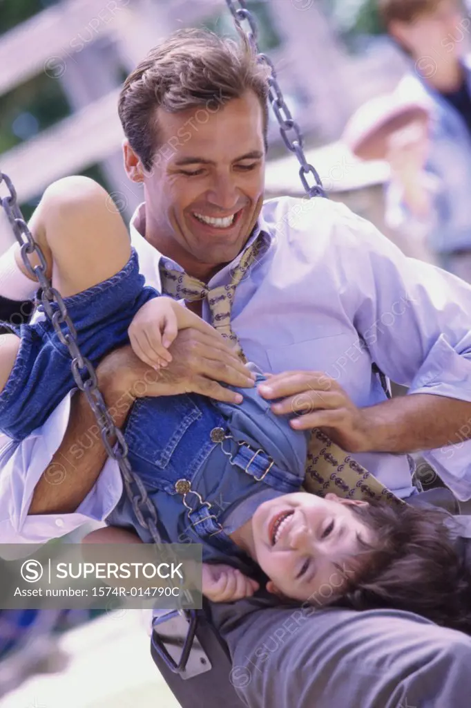 Father sitting on a swing with his daughter