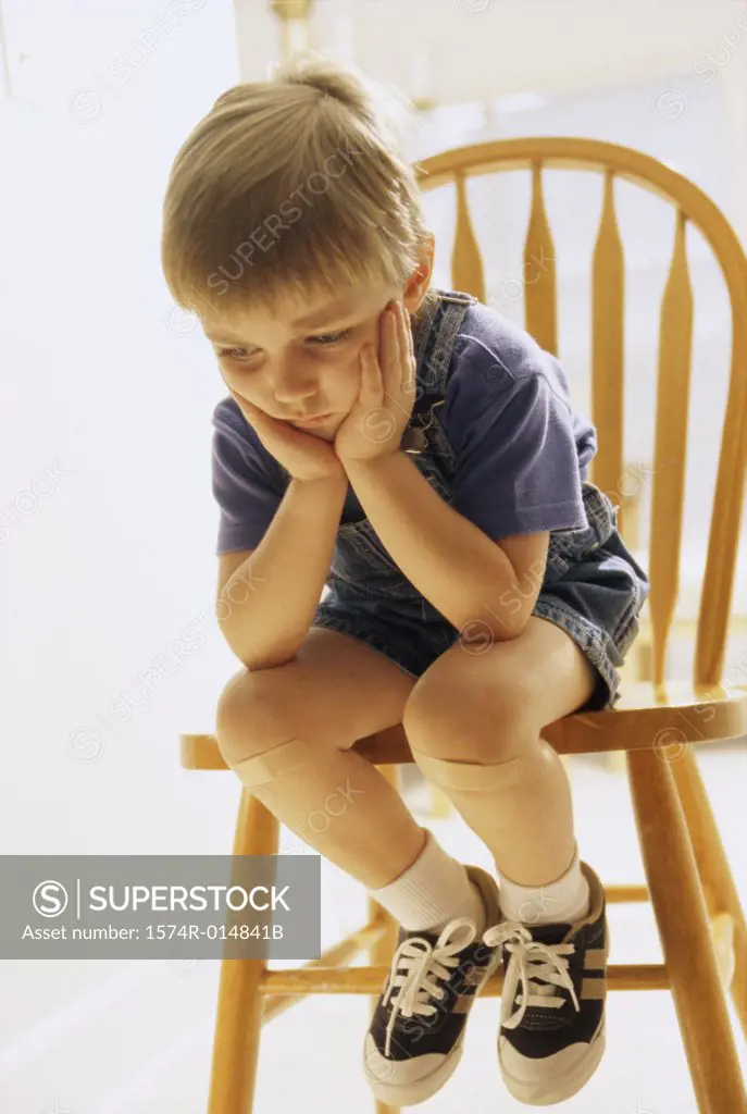 Close-up of a boy sitting on a chair