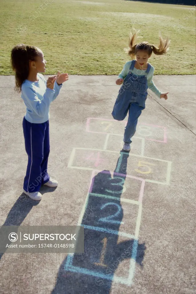 High angle view of two girls playing hopscotch