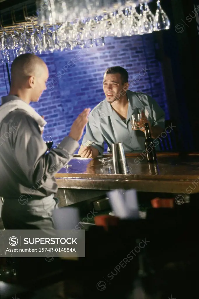 Side profile of a bartender refusing a drink to a young man
