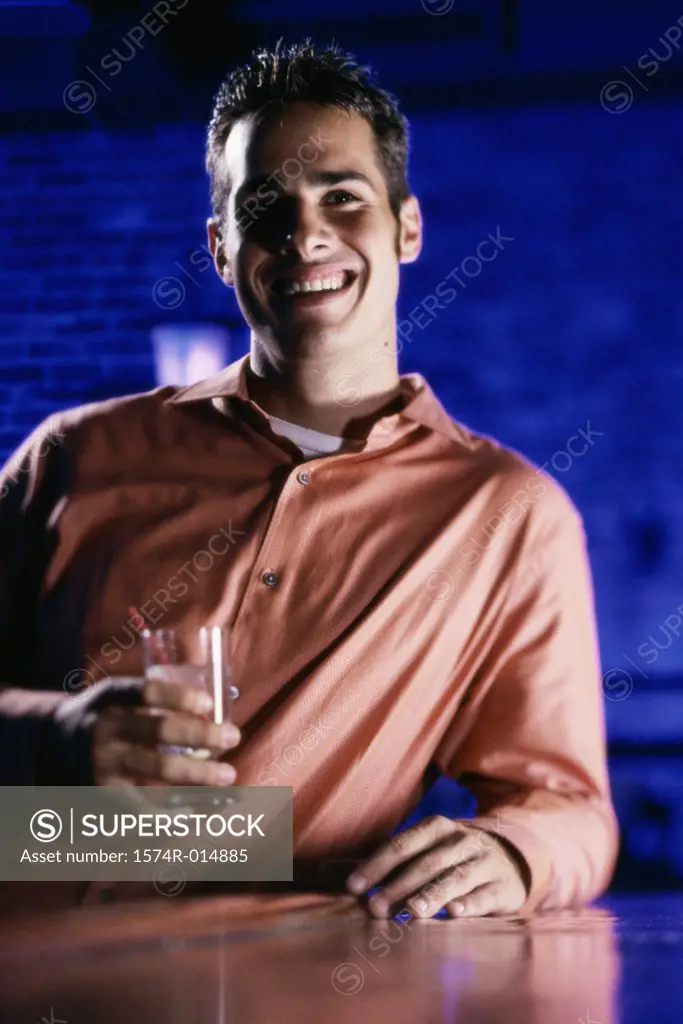 Close-up of a young man holding a drink and smiling