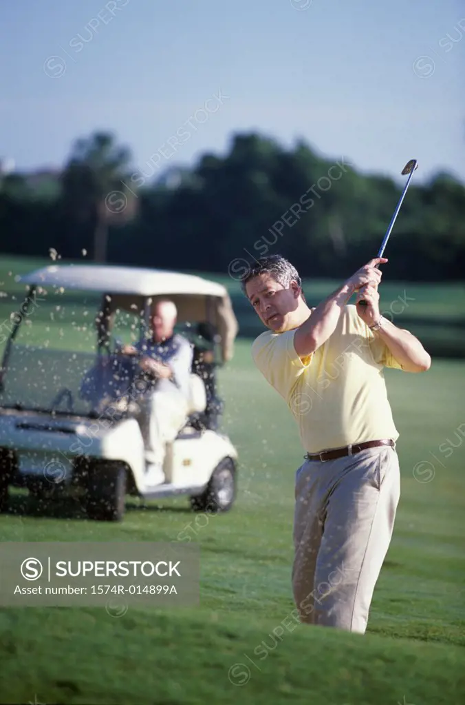 Portrait of a mature man swinging a golf club