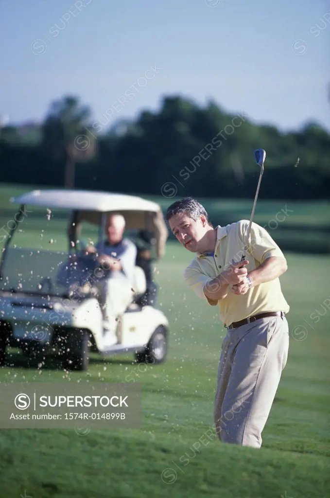 Portrait of a mature man swinging a golf club
