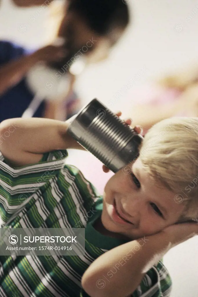 Two boys playing with a tin can phone
