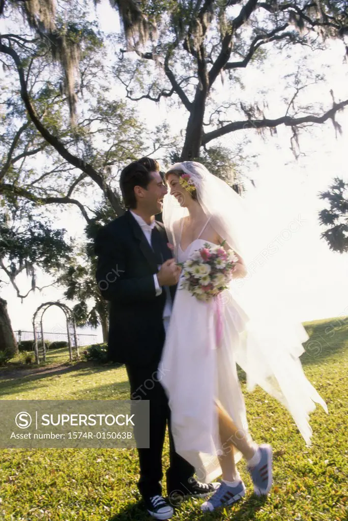 Side profile of a newlywed couple standing in a park