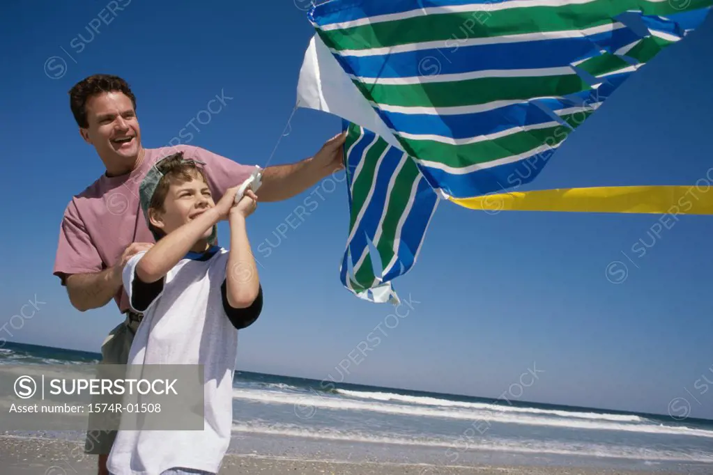 Father and son flying a kite at the beach