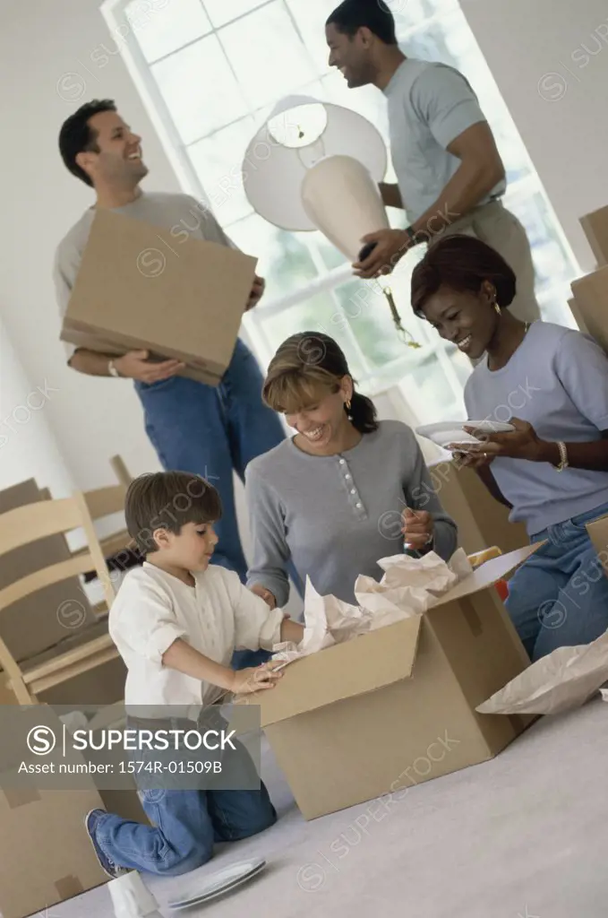 Two young couples unpacking boxes in a new home