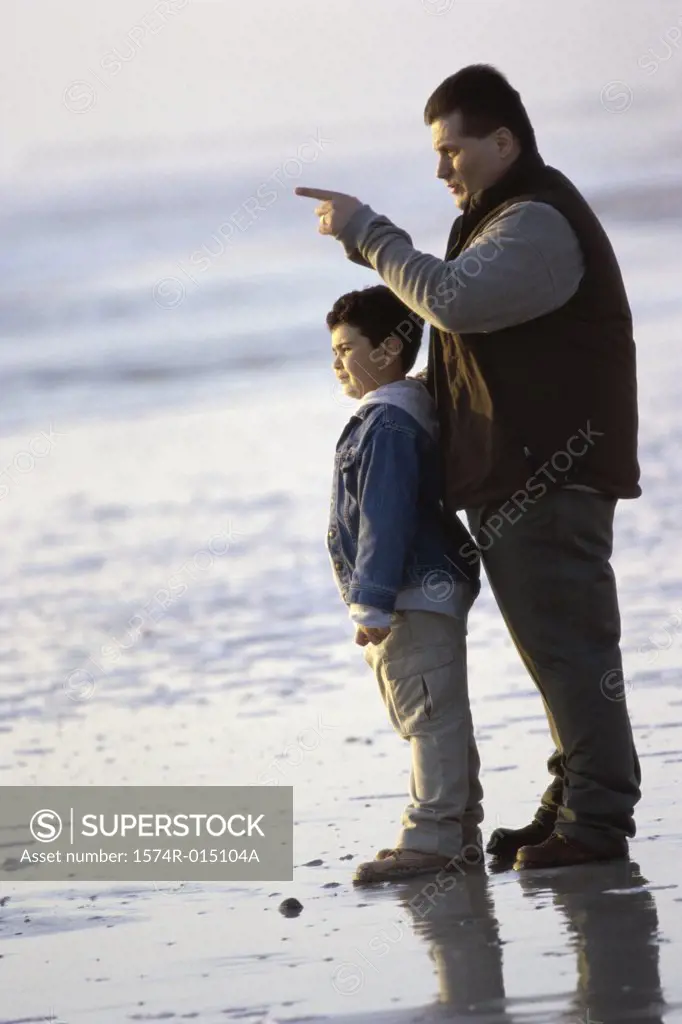Side profile of a father and son standing on the beach
