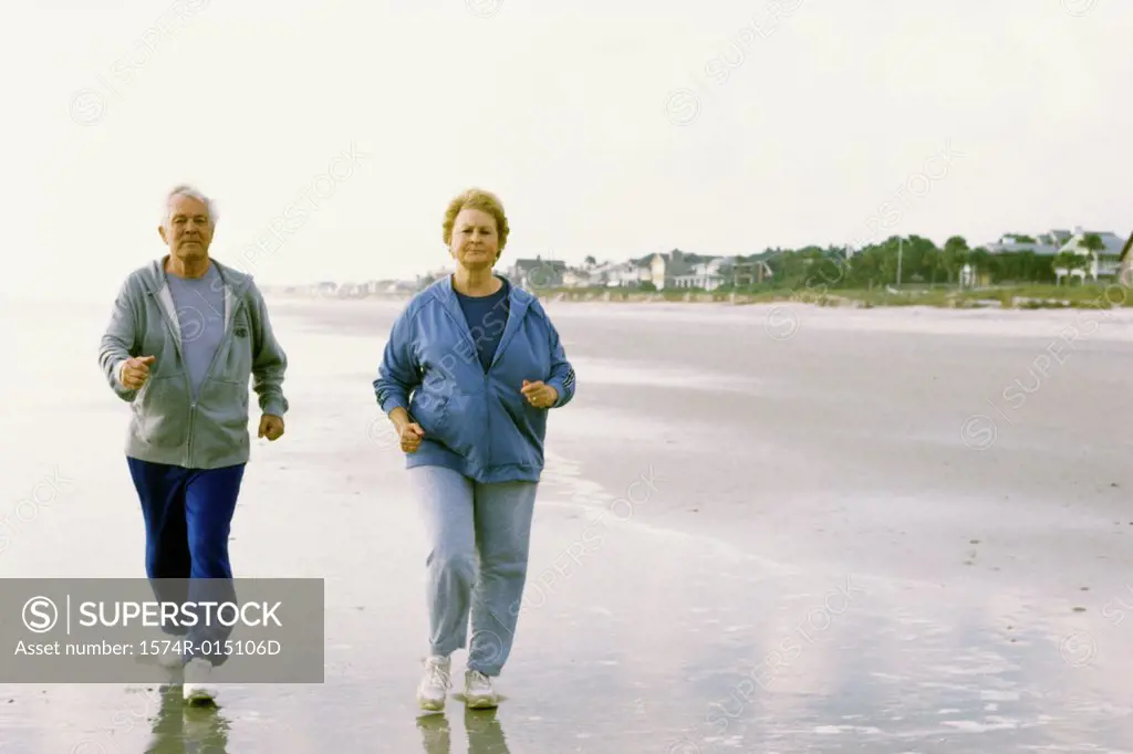 Senior couple jogging on the beach