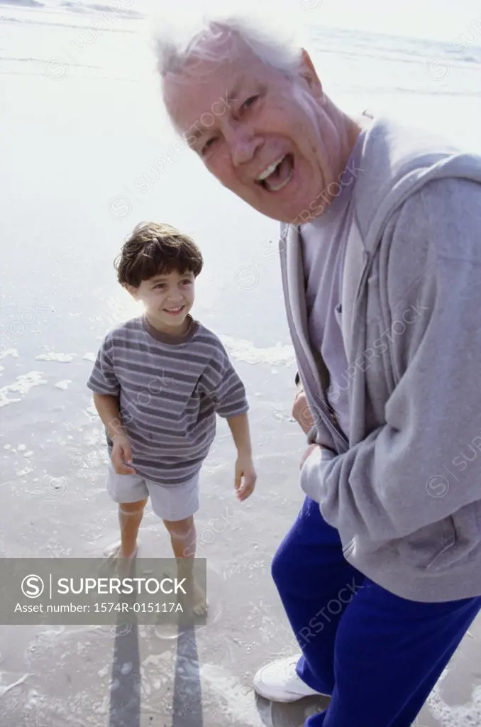 Portrait of a grandfather laughing with his grandson on the beach