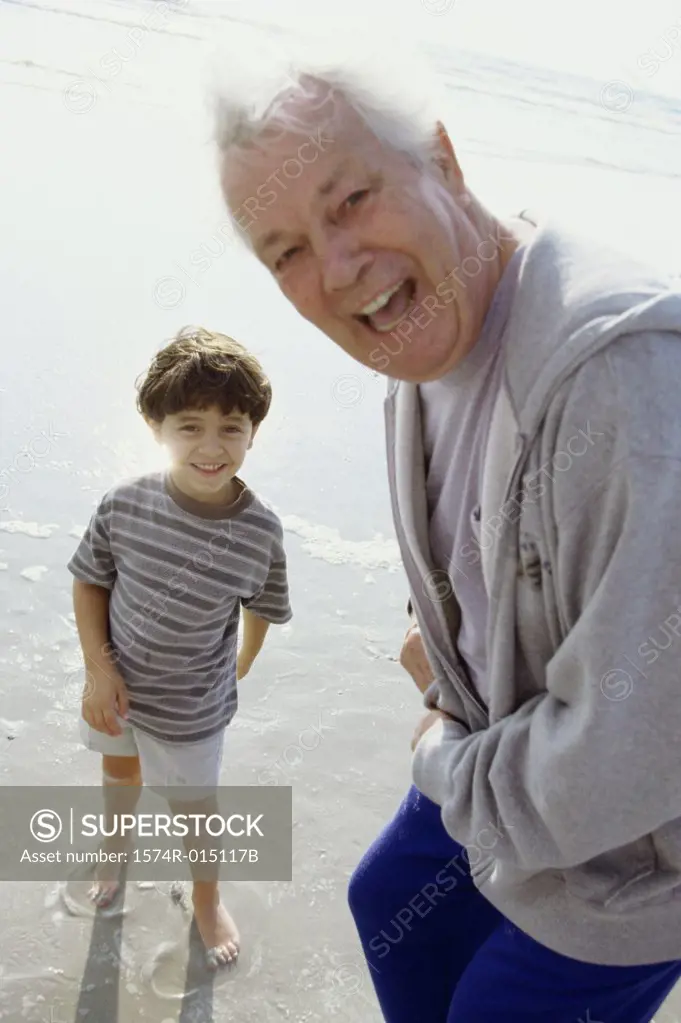 Portrait of a grandfather laughing with his grandson on the beach