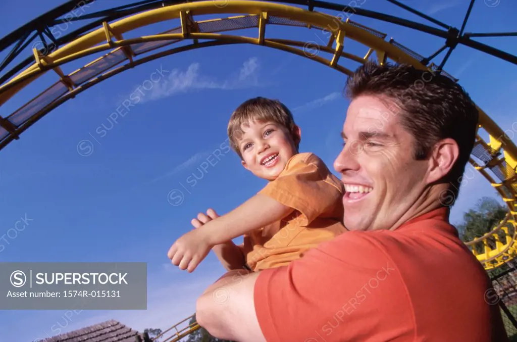 Close-up of a father carrying his son in an amusement park