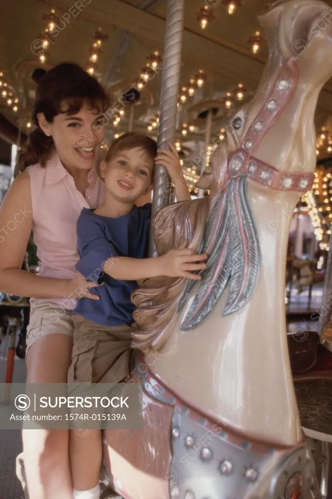 Mother and son riding a carousel horse