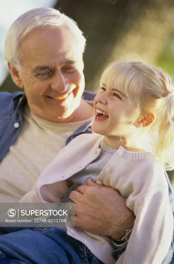 Close-up of a grandfather smiling with his granddaughter