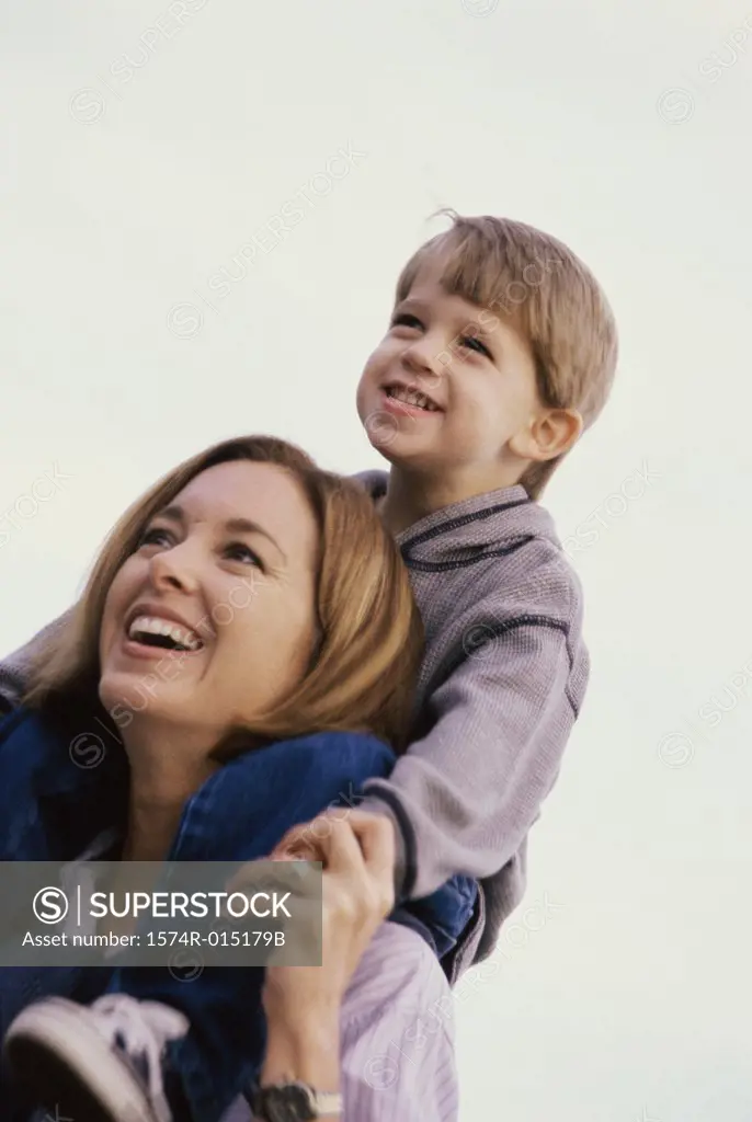 Low angle view of a son sitting on his mother's shoulders