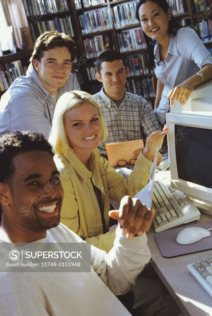 Five college students in a library smiling