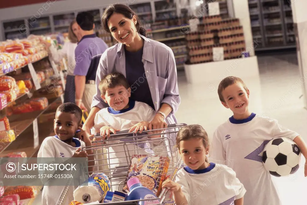 Portrait of a woman grocery shopping with four children from a football team