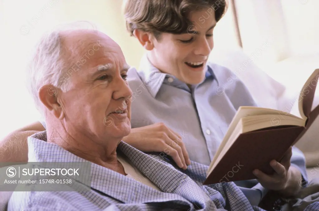 Teenage boy reading to an elderly man