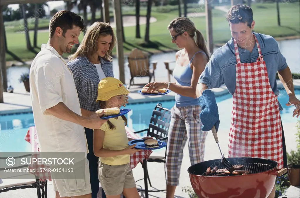 Young man serving hot dogs at a barbecue