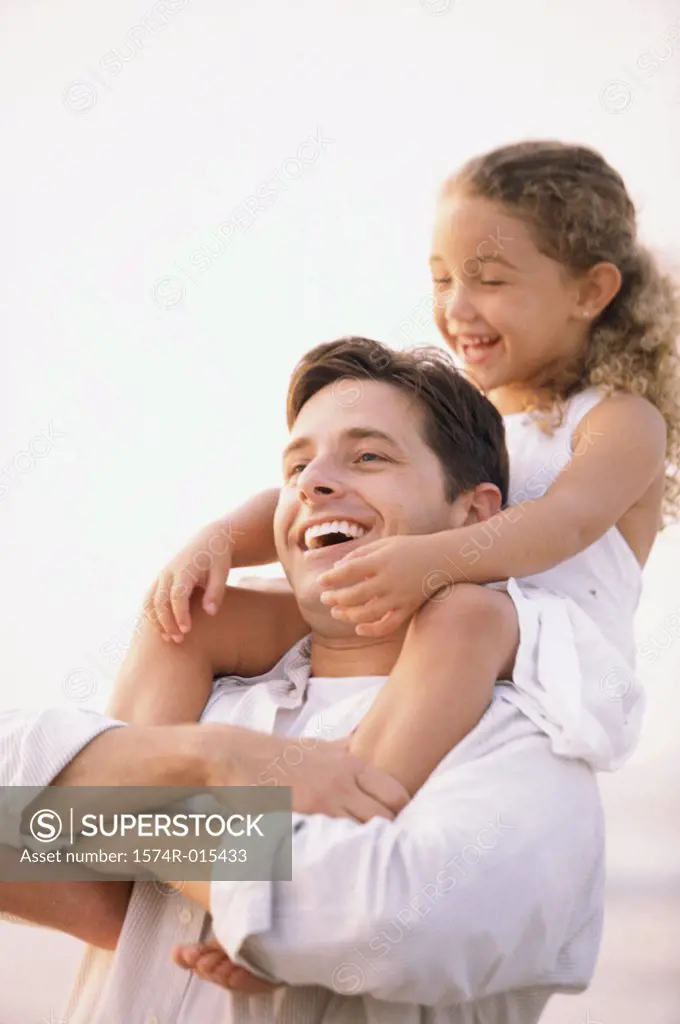 Close-up of a father carrying his daughter on his shoulders