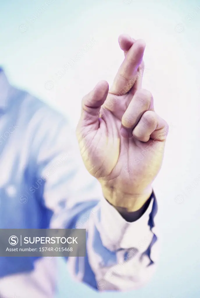 Close-up of a businessman's fingers crossed