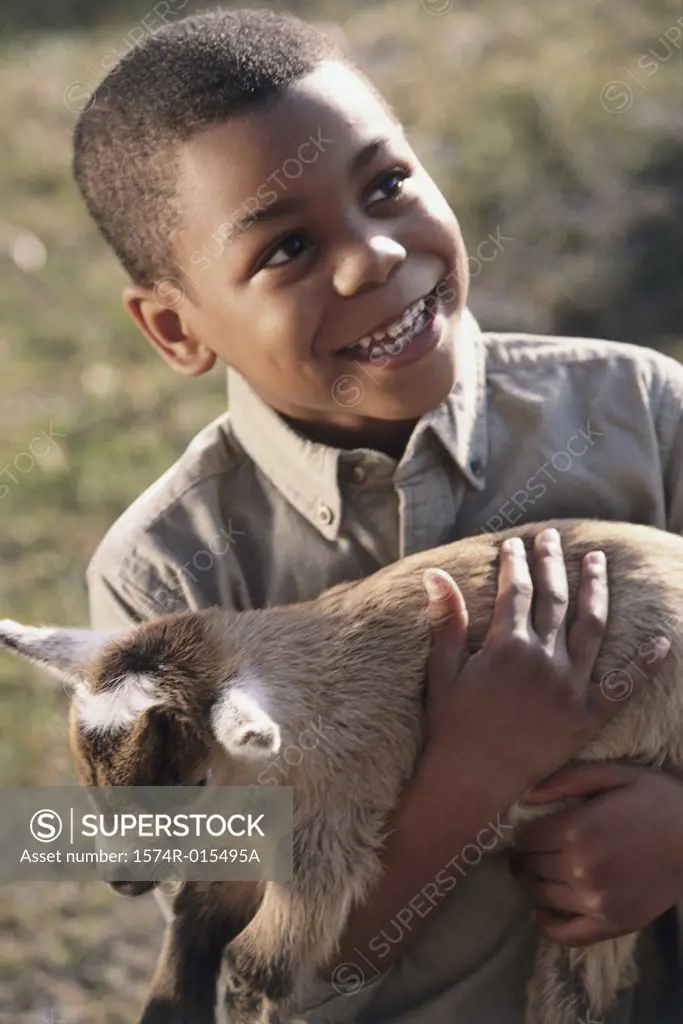 Close-up of a boy holding a lamb